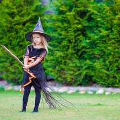 可爱的女孩穿女巫服装万圣节秋天一天技巧治疗