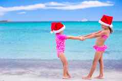 可爱的女孩红色的圣诞老人帽子海滩热带假期