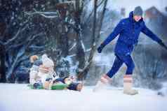 女孩享受滑雪橇父亲滑雪橇可爱的女儿家庭假期圣诞节夏娃在户外