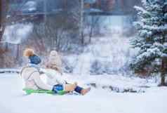 可爱的女孩享受雪橇骑孩子滑雪橇孩子们玩在户外雪家庭假期圣诞节夏娃在户外