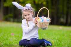 有吸引力的女孩穿兔子耳朵篮子完整的复活节鸡蛋春天一天在户外