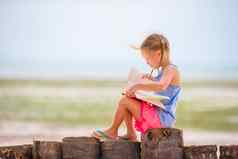 可爱的女孩阅读书热带白色海滩