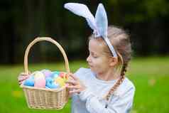 可爱的女孩穿兔子耳朵持有篮子复活节鸡蛋春天一天