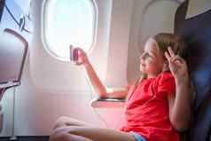 可爱的女孩旅行飞机孩子听音乐坐着飞机窗口