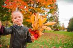 可爱的女孩采取自拍肖像黄色的橙色叶子花束在户外美丽的秋天一天