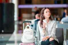年轻的女人咖啡机场休息室等待飞行飞机