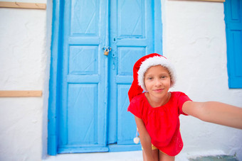 可爱的litttle女孩圣诞老人他采取自拍狭窄的街希腊村