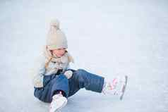 可爱的女孩坐着冰溜冰鞋秋天