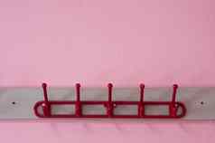 红色的彩色布悬挂器粉红色的墙