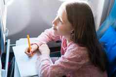 可爱的女孩旅行飞机孩子画图片色彩斑斓的铅笔坐着窗口