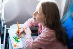 可爱的女孩旅行飞机孩子画图片色彩斑斓的铅笔坐着飞机窗口
