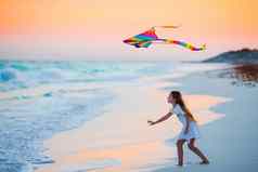 运行女孩飞行风筝热带海滩日落孩子们玩海洋海岸孩子海滩玩具