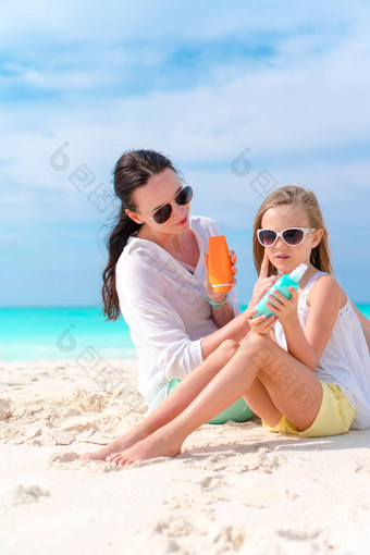 妈妈应用太阳奶油孩子鼻子海滩概念保护紫外线辐射