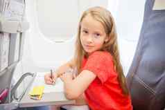 可爱的女孩旅行飞机孩子画图片色彩斑斓的铅笔坐着窗口