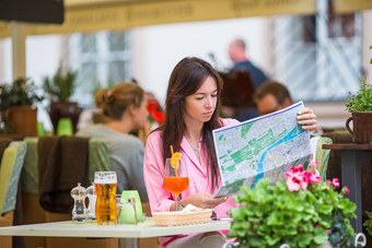 美丽的女人坐着咖啡馆户外地图快乐旅游享受欧洲假期露天restaraunt