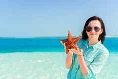 快乐年轻的女人海星白色海滩自然储备