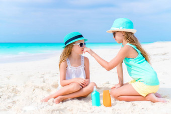女孩应用太阳奶油海滩概念保护紫外线辐射