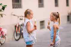 可爱的女孩吃冰淇淋在户外夏天