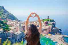 美丽的女孩使手心形状沿海小镇背景vernazza五渔村国家公园利古里亚意大利欧洲