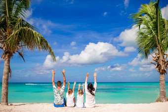 年轻的家庭走白色热带加勒比海滩