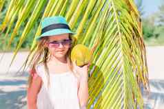 可爱的女孩大椰子白色桑迪海滩