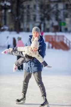 家庭父亲孩子有趣的滑冰溜冰场在户外