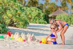 孩子们使沙子城堡有趣的热带海滩