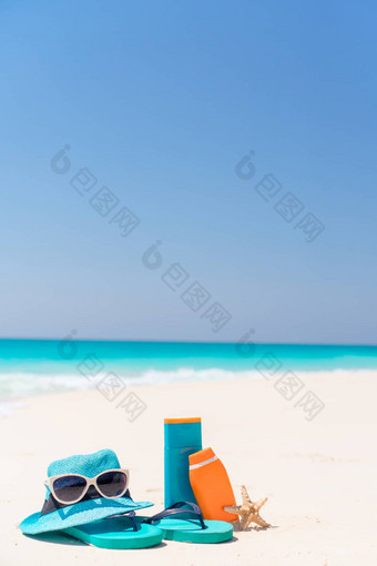 防晒霜瓶护目镜海星太阳镜白色沙子海滩背景海洋