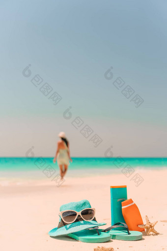 防晒霜瓶太阳镜翻转失败白色沙子背景海洋