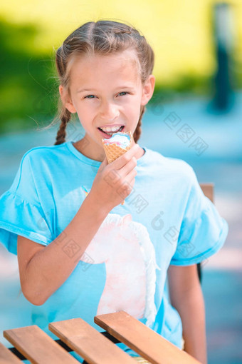 女孩吃冰淇淋在户外夏天户外咖啡馆