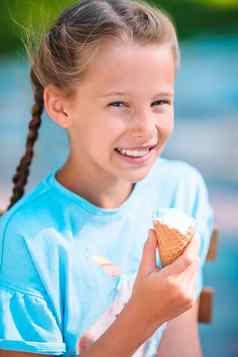 女孩吃冰淇淋在户外夏天户外咖啡馆