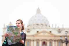 漂亮的年轻的女旅游研究地图彼得的广场