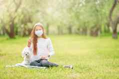 女孩狗穿保护医疗面具防止病毒在户外公园