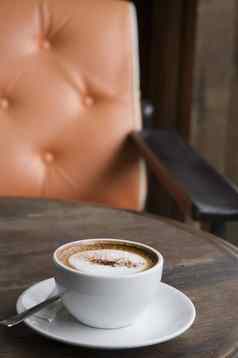 杯卡布奇诺咖啡橙色扶手椅背景