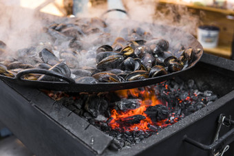 新鲜的贻贝烧烤锅海鲜烧烤在户外野餐健康的食物贻贝贝壳很多贻贝贝壳烹饪大金属锅