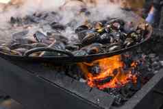 新鲜的贻贝烧烤锅海鲜烧烤在户外野餐健康的食物贻贝贝壳很多贻贝贝壳烹饪大金属锅