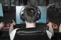 波兰华沙6月回来视图年轻的玩家耳机玩视频游戏电脑俱乐部