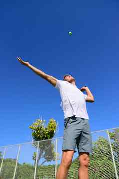 网球球员服务玩在户外体育运动男人。