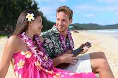 夫妇有趣的海滩玩尤克里里琴夏威夷