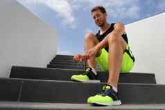 跑步者系运行鞋子鞋带准备好了运行城市楼梯健康的活跃的生活方式男人。快乐慢跑动机