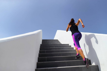 楼梯运行锻炼女人培训有氧运动健身房健身女孩锻炼腿肌肉在户外爆炸练习