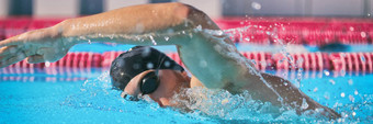 体育健身概念体育运动运动员游泳池培训有氧运动自由泳爬技术速度竞争男人。游泳运动员室内体育场车道横幅全景