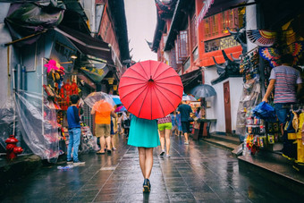 人女人走唐人街购物街多雨的一天女孩旅游红色的东方伞狭窄的小巷中国旅行上海