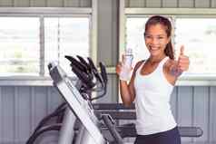 快乐健身房女人拇指有氧运动锻炼跑步机机喝水健康健身