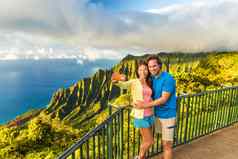 夏威夷自拍夫妇纳帕利自然考艾岛夏威夷年轻的游客采取自拍电话照片巴利语注意考艾岛夏威夷旅行人著名的卡拉劳夏威夷吸引力