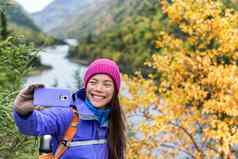 快乐亚洲徒步旅行者女人采取智能手机自拍风景优美的的观点自然秋天山景观在户外女孩徒步旅行秋天森林公园旅行生活方式女孩持有电话