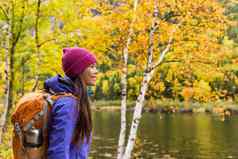 女人徒步旅行者徒步旅行风景优美的视图秋天树叶山景观冒险旅行在户外人站放松河自然徒步旅行秋天季节
