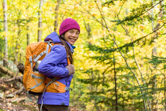 快乐背包客女孩徒步旅行秋天森林年轻的亚洲徒步旅行者女人户外齿轮冷天气背包相机享受走自然在户外秋天季节