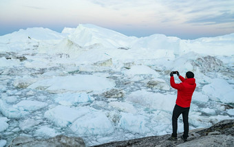 旅行<strong>北极</strong>景观自然<strong>冰山</strong>格陵兰岛旅游男人。资源管理器采取照片电话令人惊异的格陵兰岛冰峡湾伊卢利萨特影响气候改变全球气候变暖