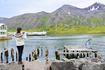 旅游冰岛采取照片锡格鲁峡湾峡湾穿冰岛毛衣女人参观冰岛观光锡格鲁峡湾城市采取图片电话相机北冰岛图片